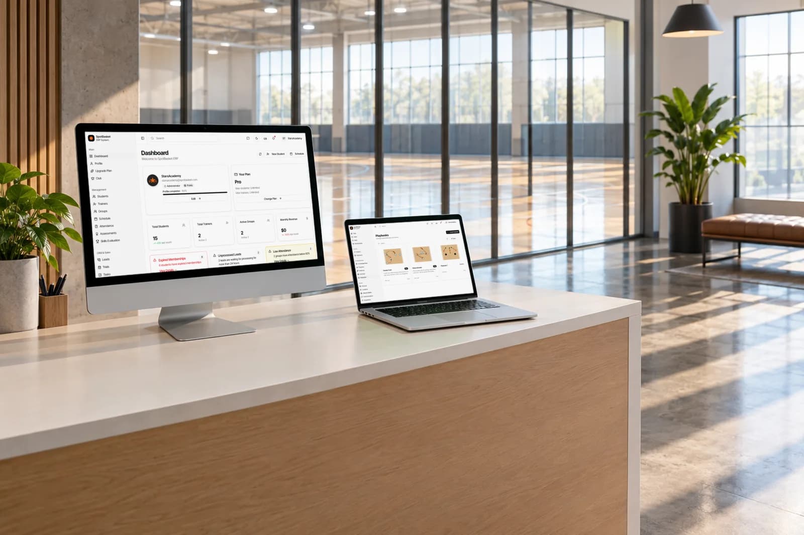 SpotBasket OS basketball club management software dashboard on a laptop next to a basketball court