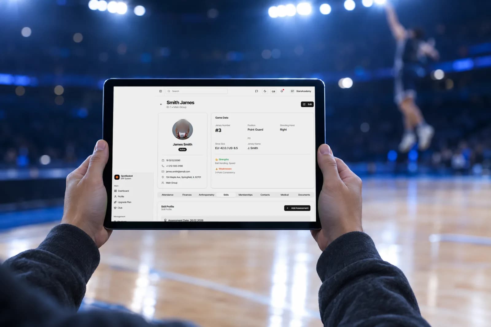 Coach scoring a basketball player evaluation on a tablet during a tryout