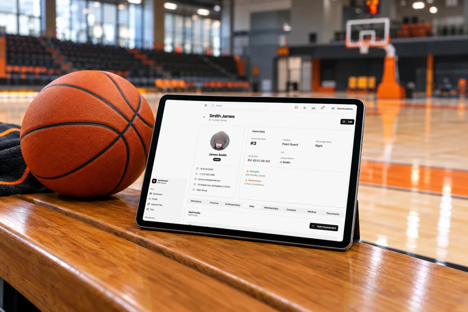 Coach scoring a basketball player evaluation on a tablet during a tryout