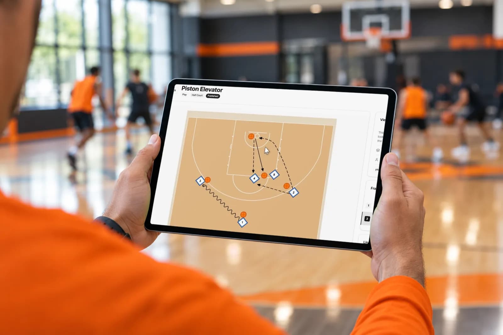 SpotBasket basketball playbook maker on an iPad at courtside showing an animated half-court play